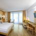 JUFA Hotel Bruck an der Mur - im Weitental room with double bed, desk, sofa and balcony doors