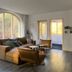 Landgoed Huize Glory in Bergen aan Zee living room with large arched window and seating area