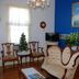 Lost Bayou Guesthouse in Galveston: Victorian-style sitting room with chandelier, blue accent wall, and antique seating