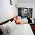 Hanoi Crystal Hotel Hanoi room with two beds, TV, desk and white walls