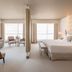 Epic Sana Marques Hotel Lisbon suite with king bed, seating area and large windows with city views
