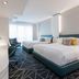 Warwick Le Crystal - Montréal guest room with two beds, seating area, and city-view window in Montreal