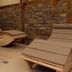 Gasthof Bärnstatt in Scheffau am Wilden Kaiser with four wooden lounge chairs in a stone-walled relaxation room