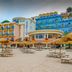 Summit Hotel in Gaeta with beachfront umbrellas and loungers in front of a colorful seaside facade