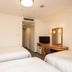 Court Hotel Shinyokohama in Yokohama guest room with three beds, TV, and desk