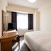 Court Hotel Shinyokohama in Yokohama guest room with bed, desk, TV and window light