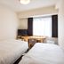 Court Hotel Shinyokohama in Yokohama: compact twin room with two beds and desk by window
