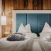 Sendlhofer's in Bad Hofgastein: twin beds with teal headboard and rolled gray towels in a wood-paneled room