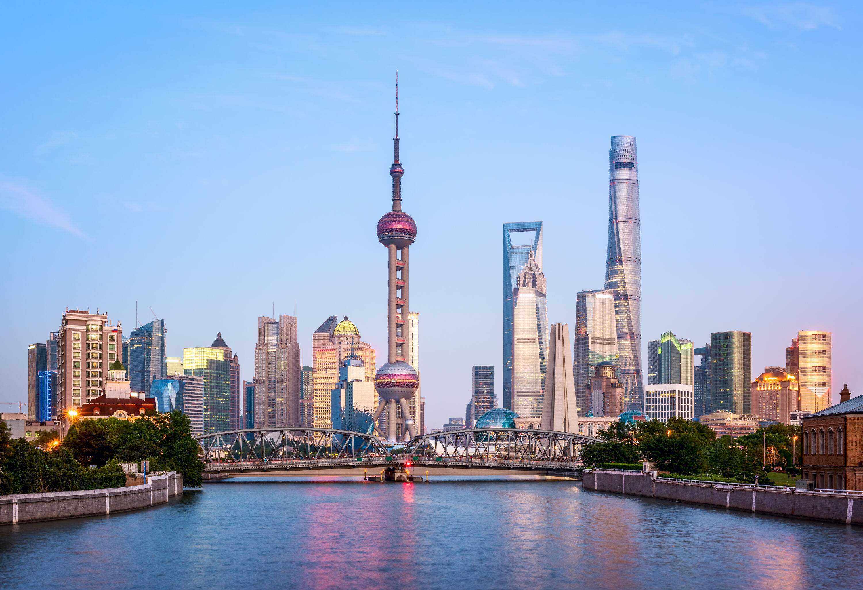 The Shanghai skyline, dominated by towering skyscrapers, is punctuated by the iconic, futuristic design of the Oriental Pearl TV Tower, standing tall in the centre.