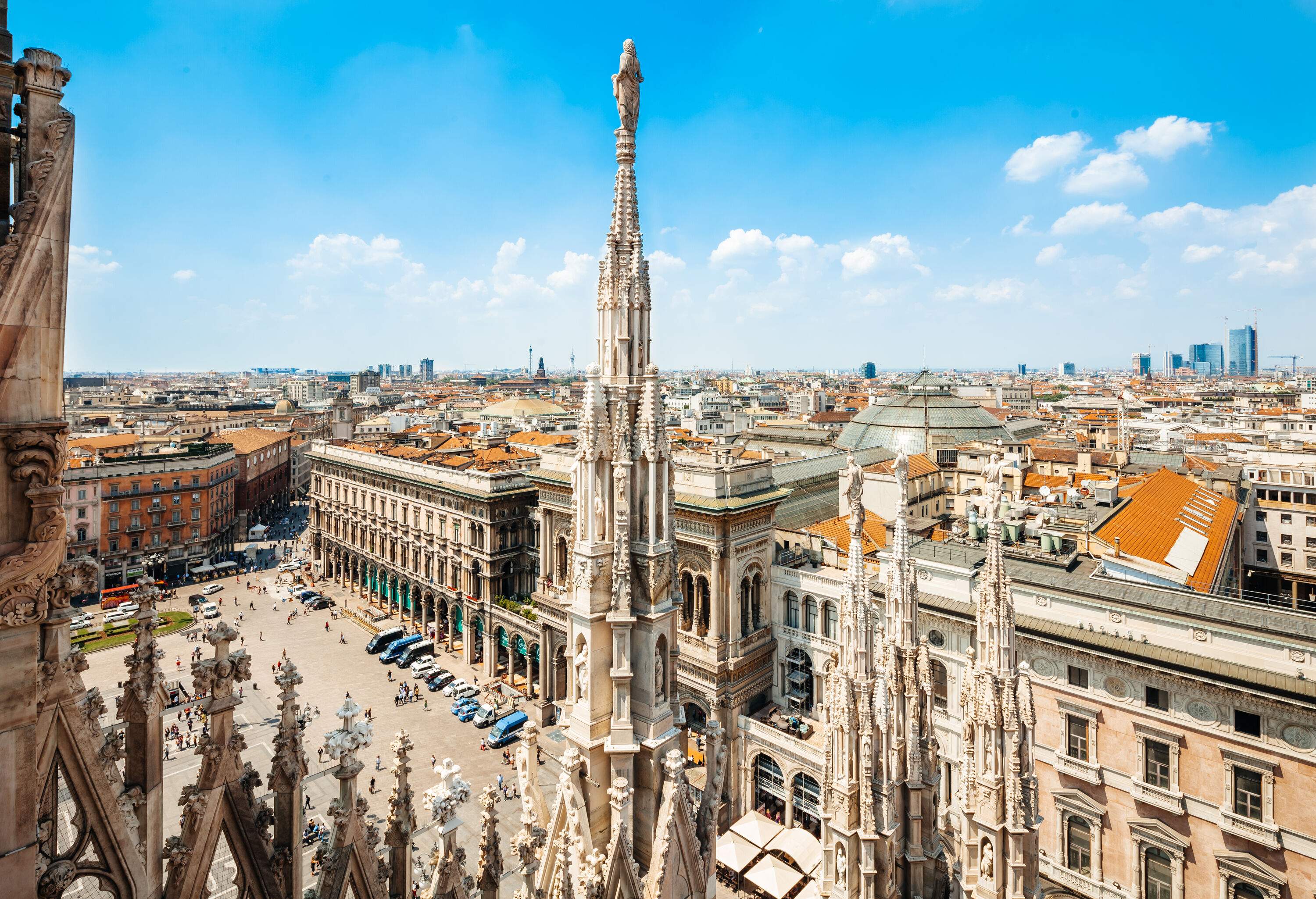 Skyline of the old city and a bustling city square with Italy's oldest active shopping gallery in Milan.
