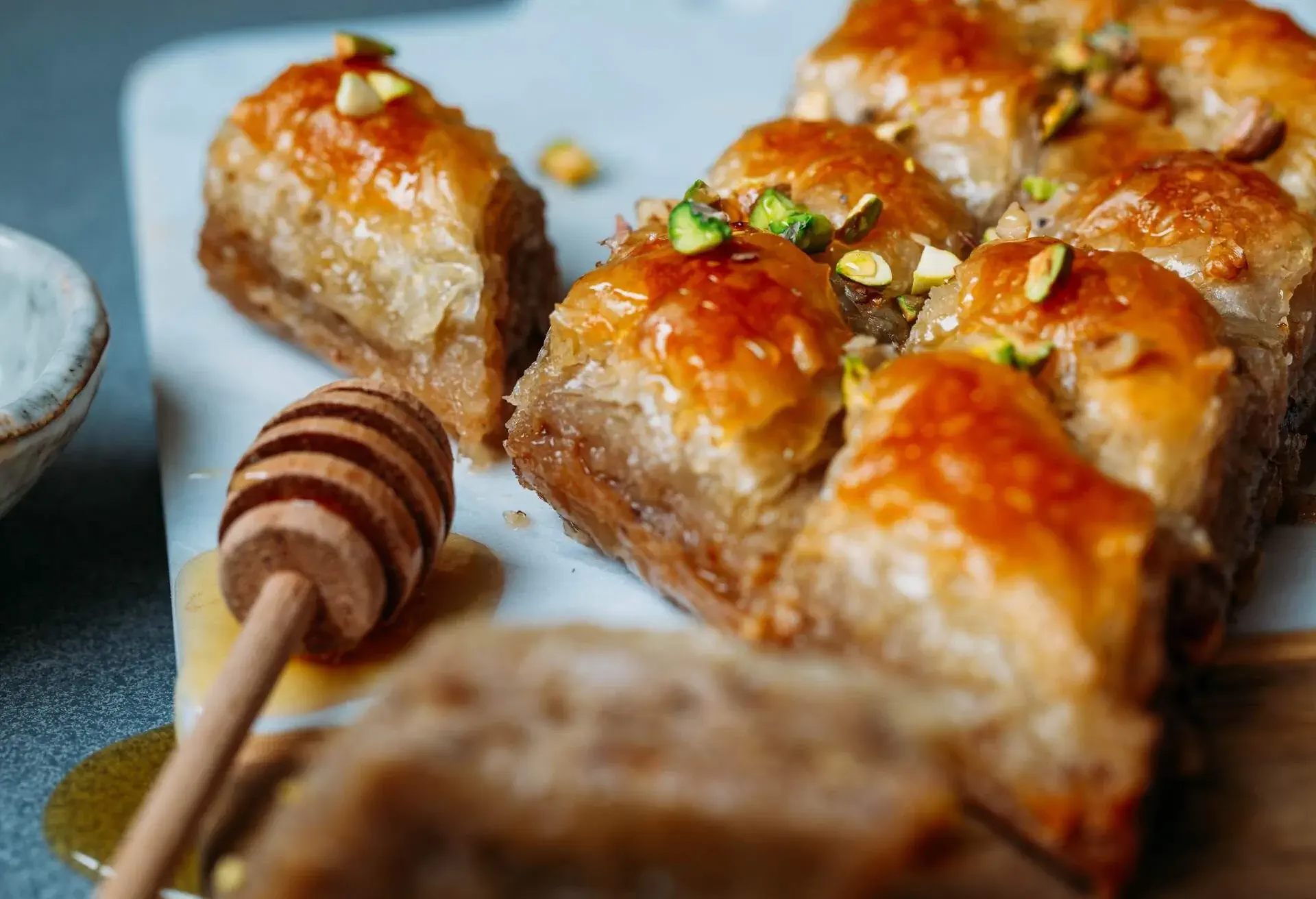 Baklava with honey on a white board