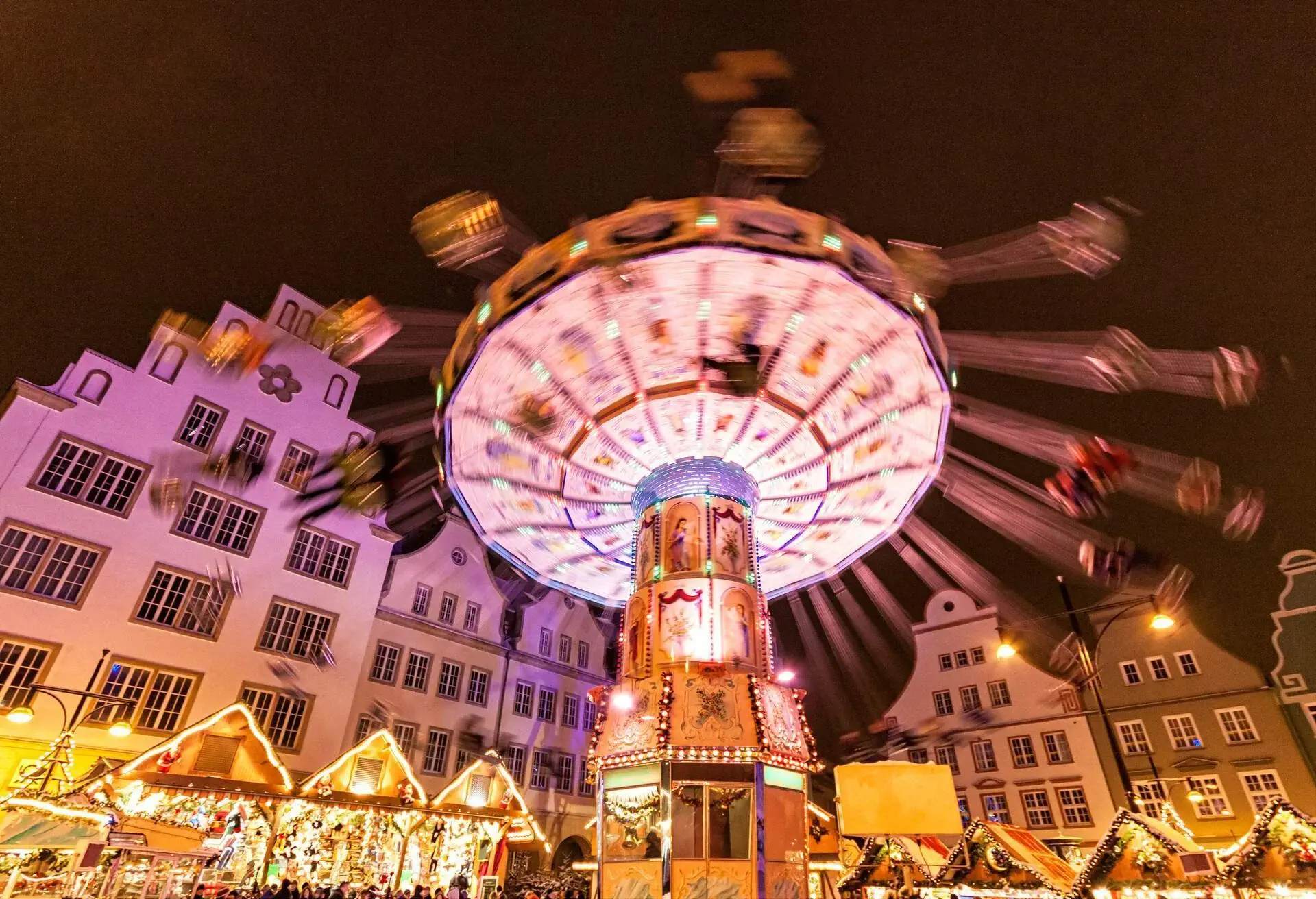 Traditional fairground ride in motion at Rostock Christmas market in town square in the evening