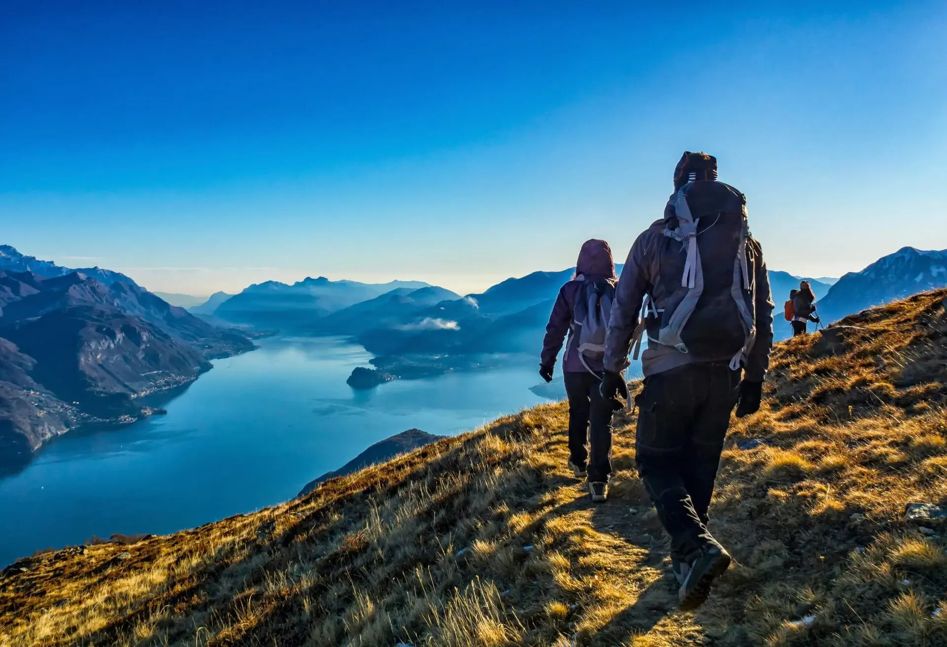 Three people hiking above Lake Como, Italy