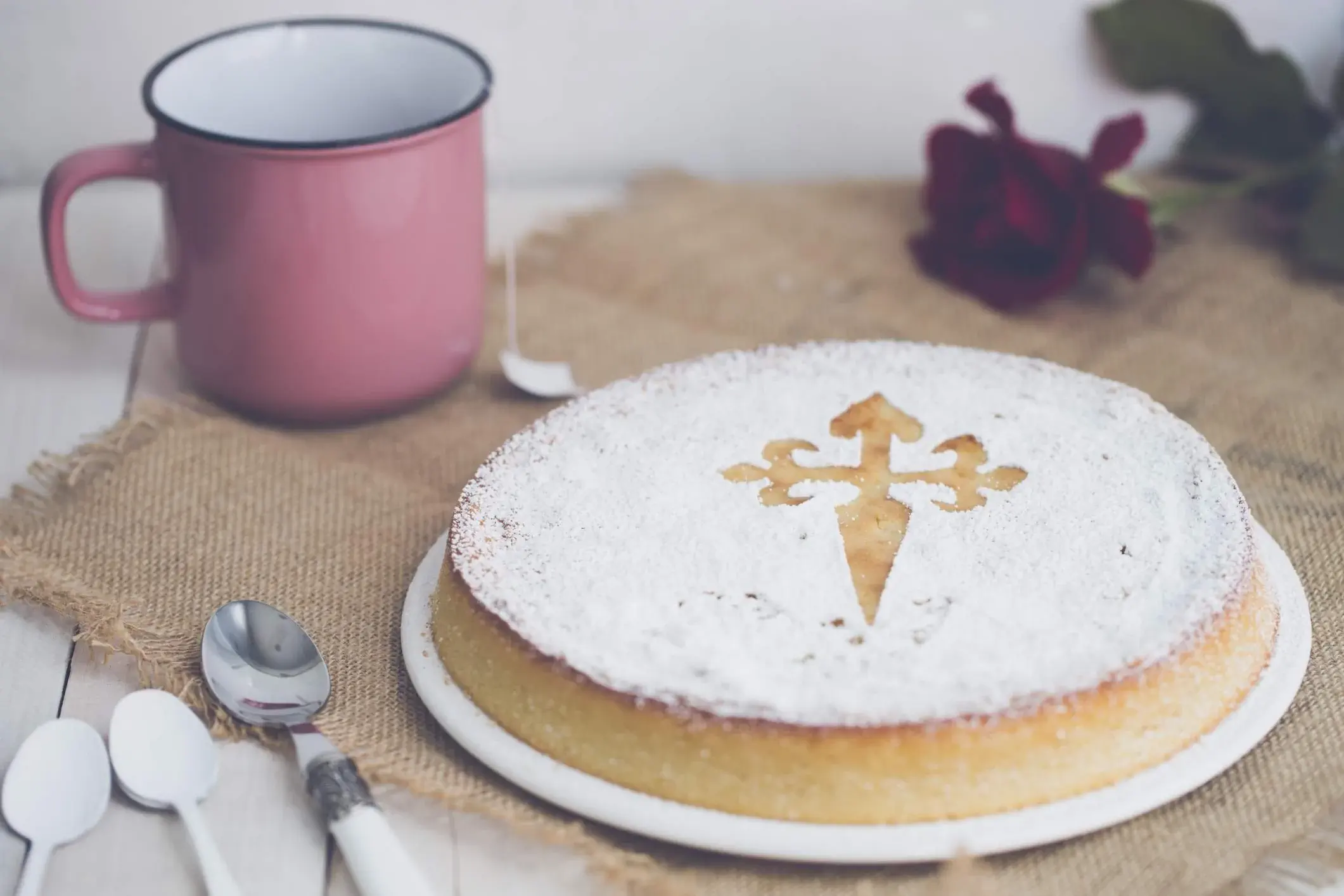 Tarta de Santiago with powdered sugar and pink tea mug