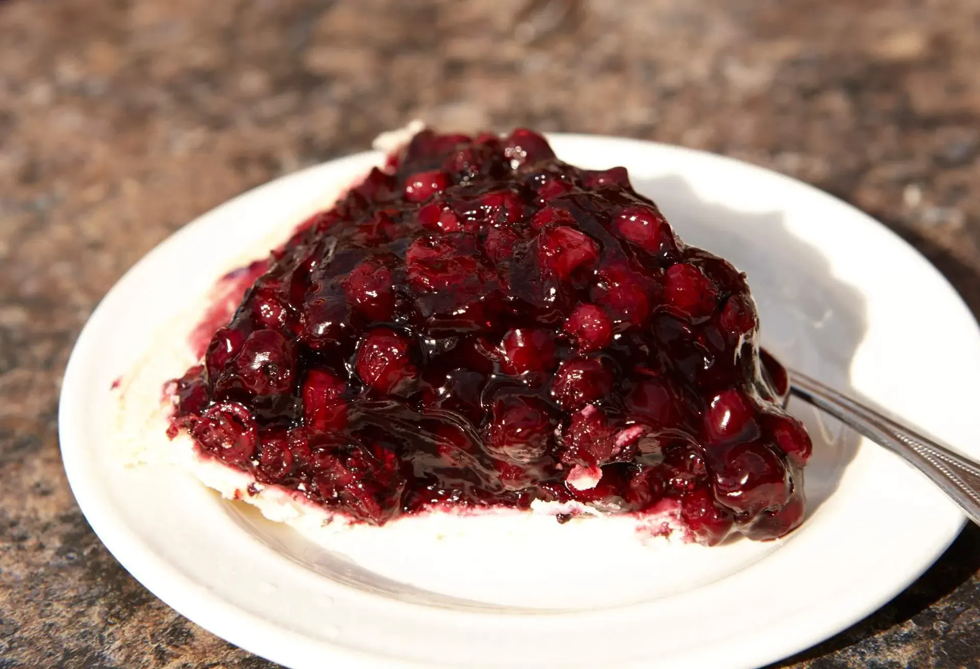 Slice of Saskatoon berry pie on a white plate