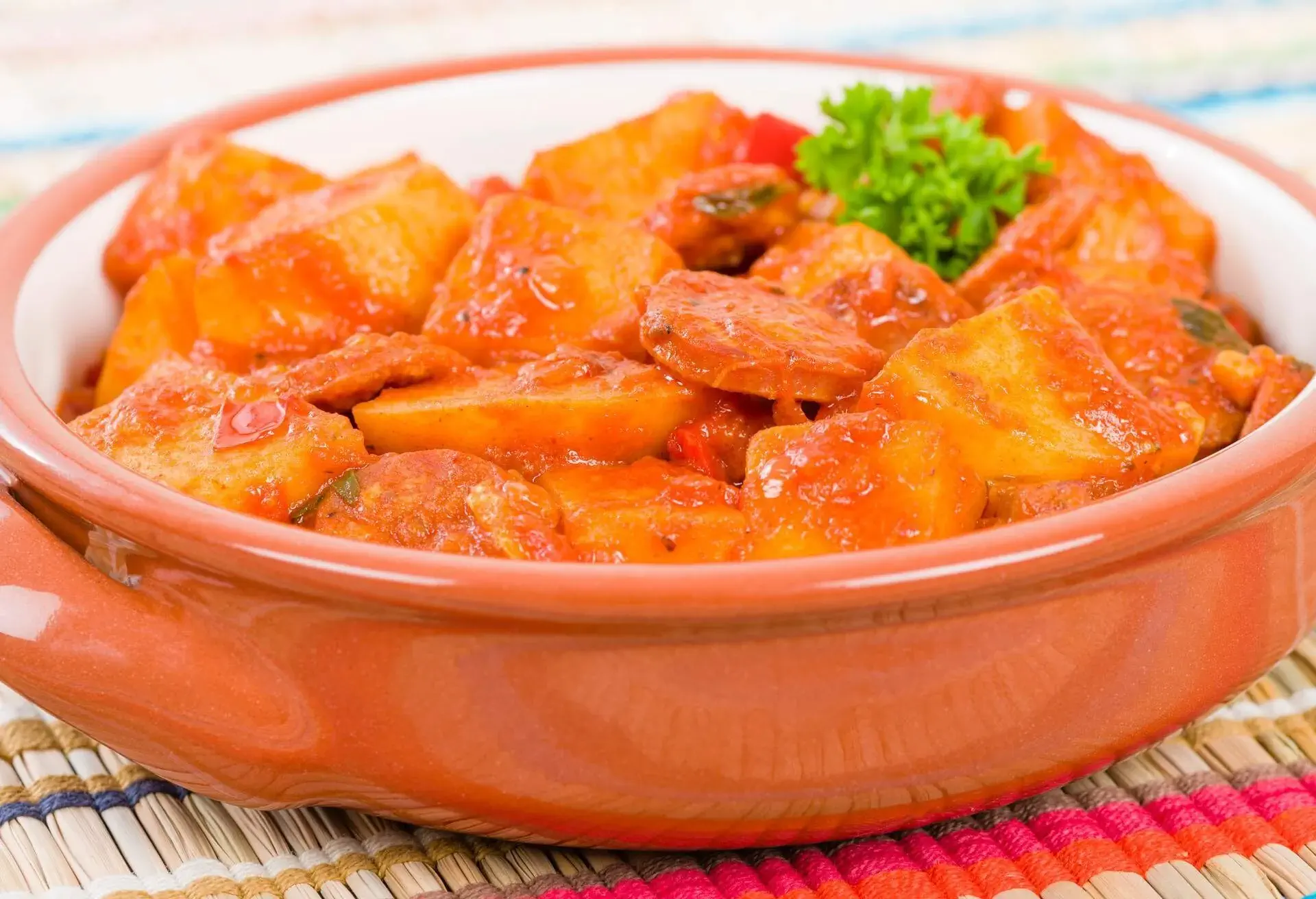 Patatas bravas in a terracotta bowl