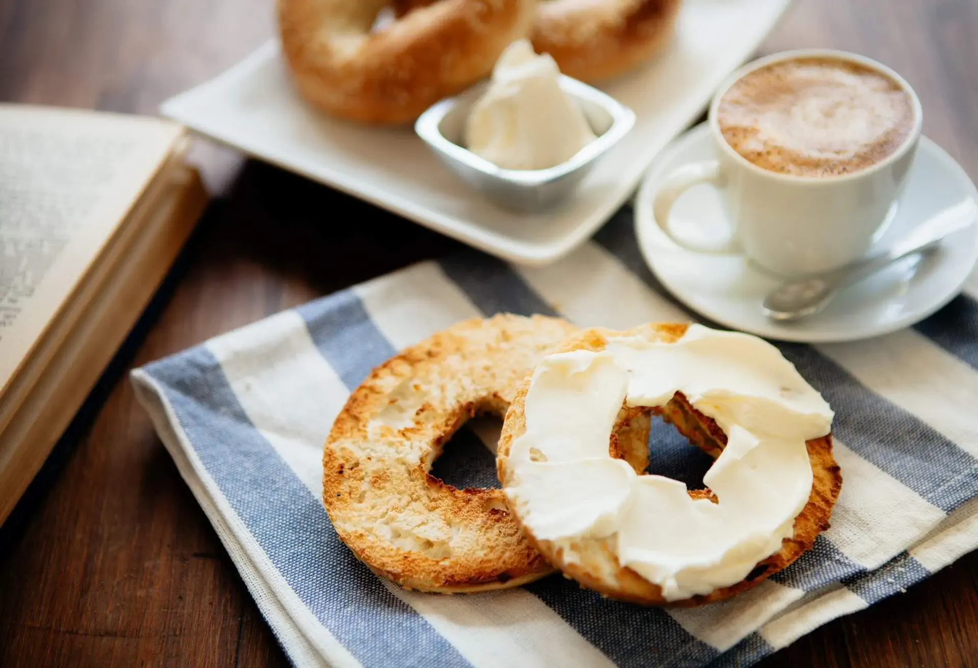 Bagel with creamcheese and cappuccino in a white cup