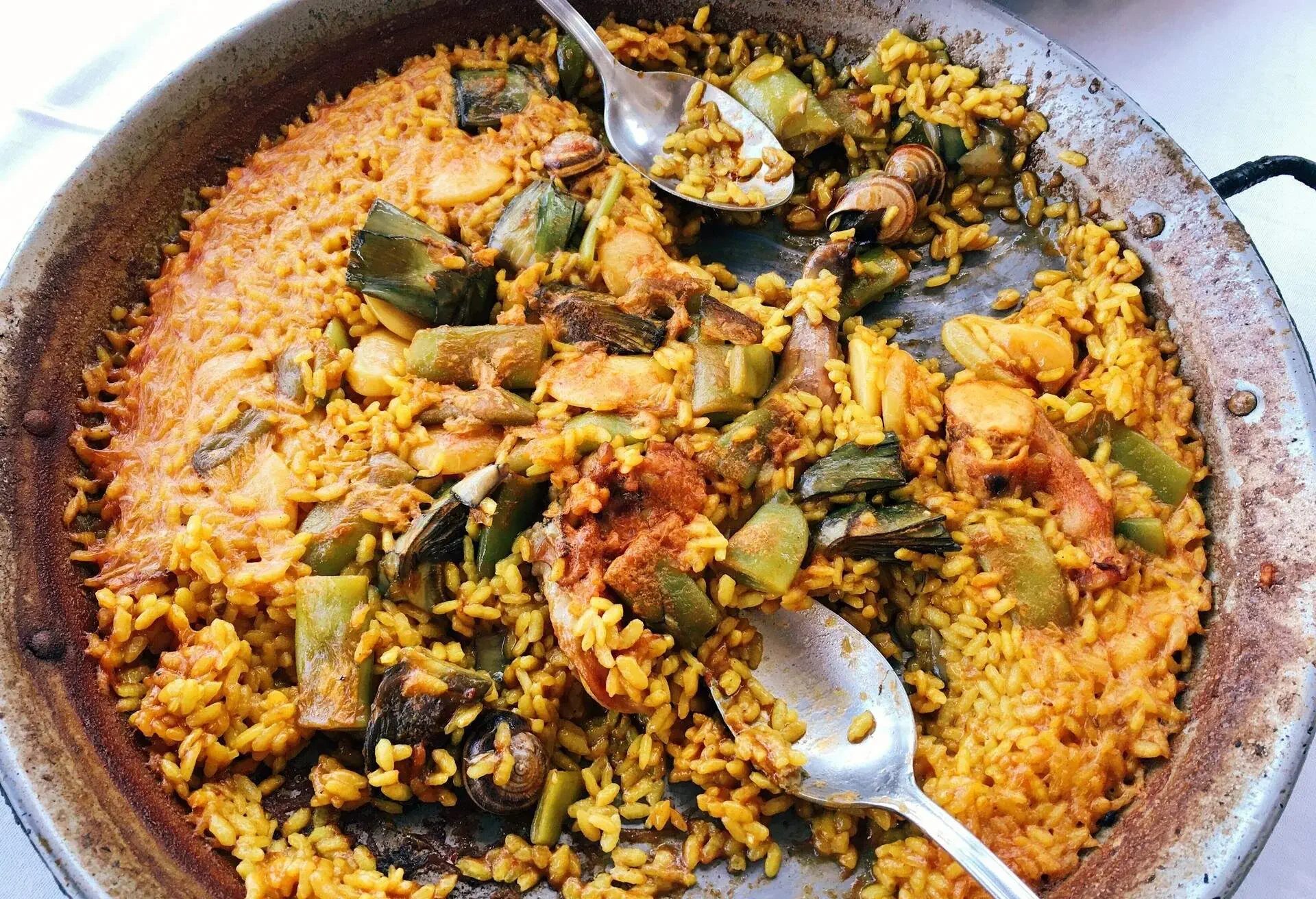 Paella Valenciana in a paella pan with spoons