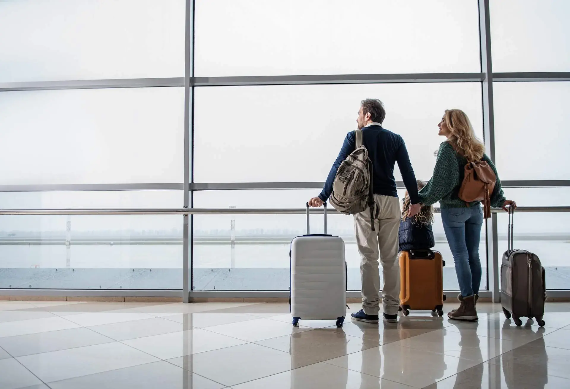 A man, a woman and a child with suitcases at the airport