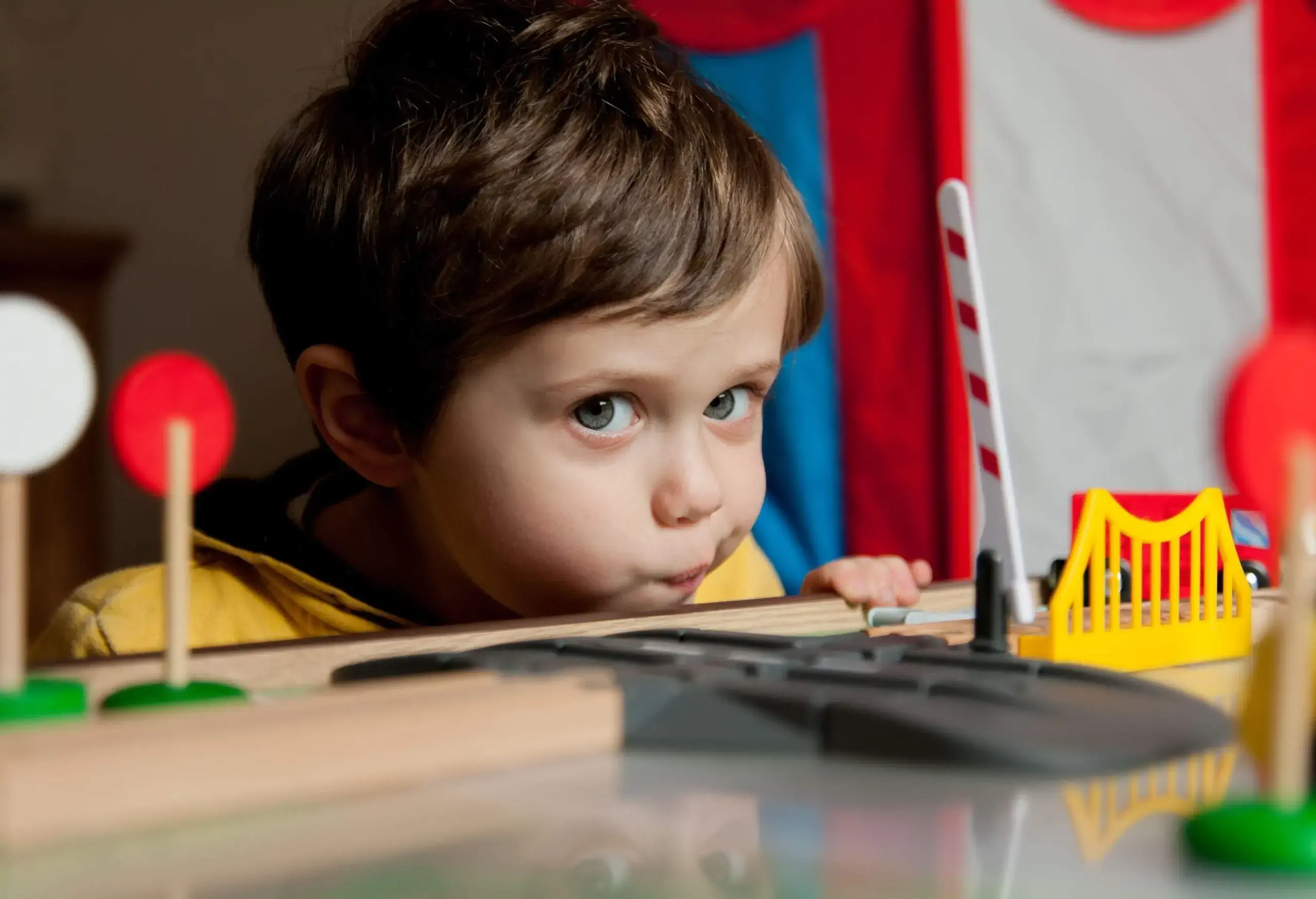 A little boy plays with train toys.