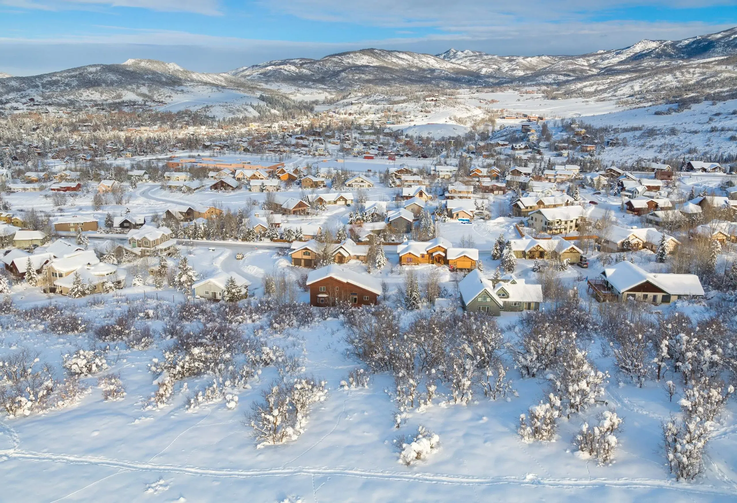A cluster of homes in a rural village covered in heavy snow.