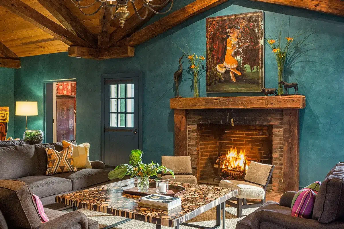 Cozy living room with a lit fireplace, beamed ceiling, and rustic decor.