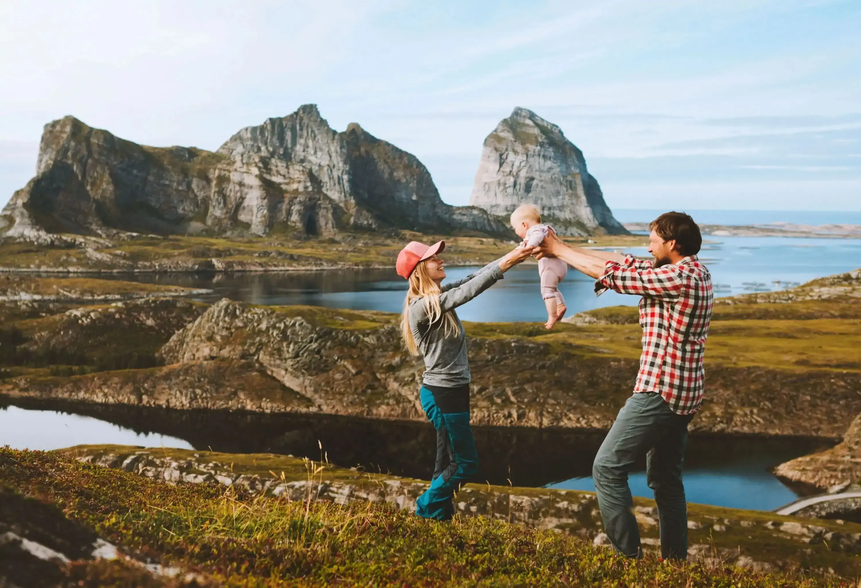 Family couple mother and father with baby  travel vacations outdoor man and woman with kid healthy lifestyle trip in Norway Helgeland islands happy emotions