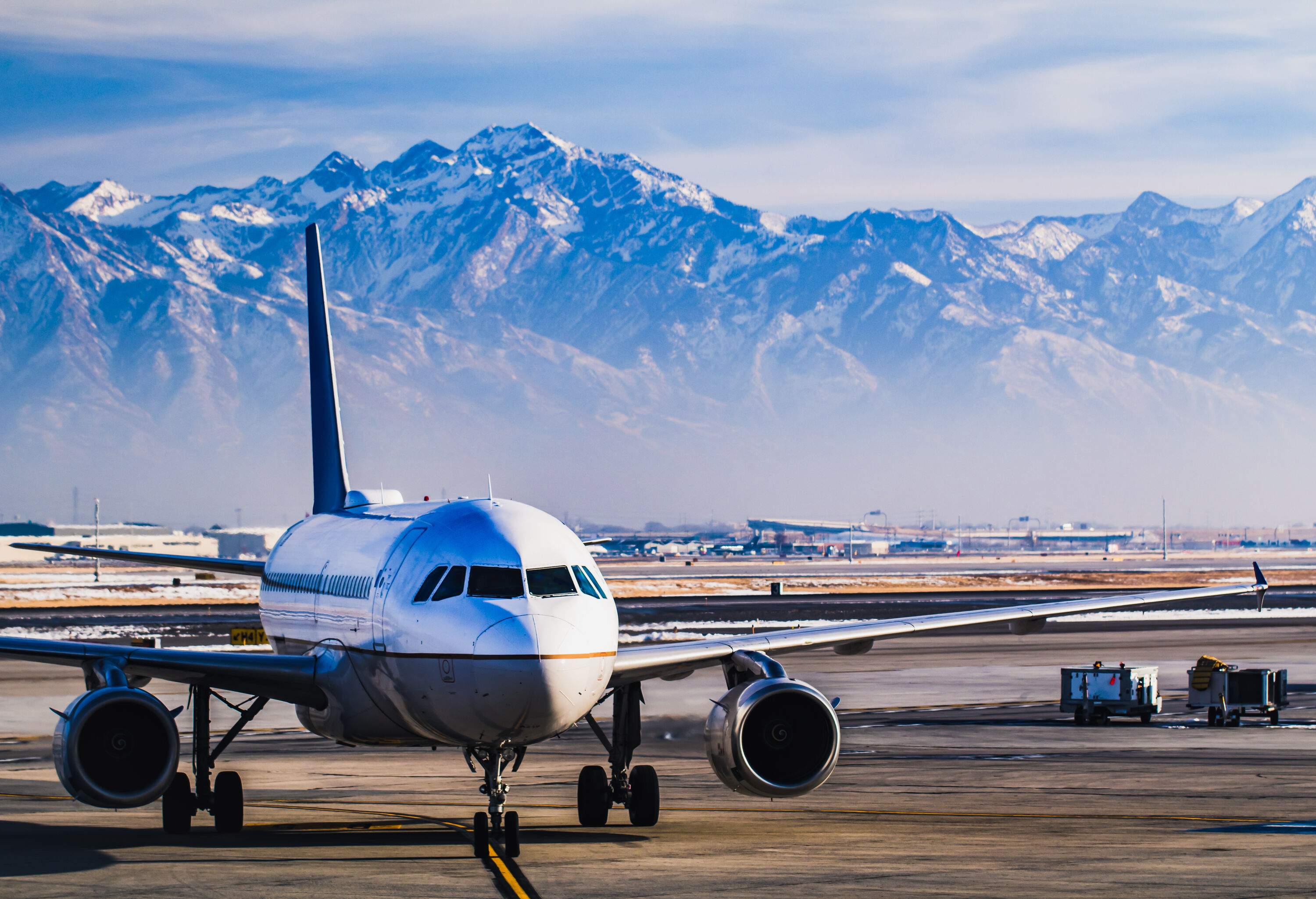 An aeroplane in the flight line with snow-covered mountains in the background.