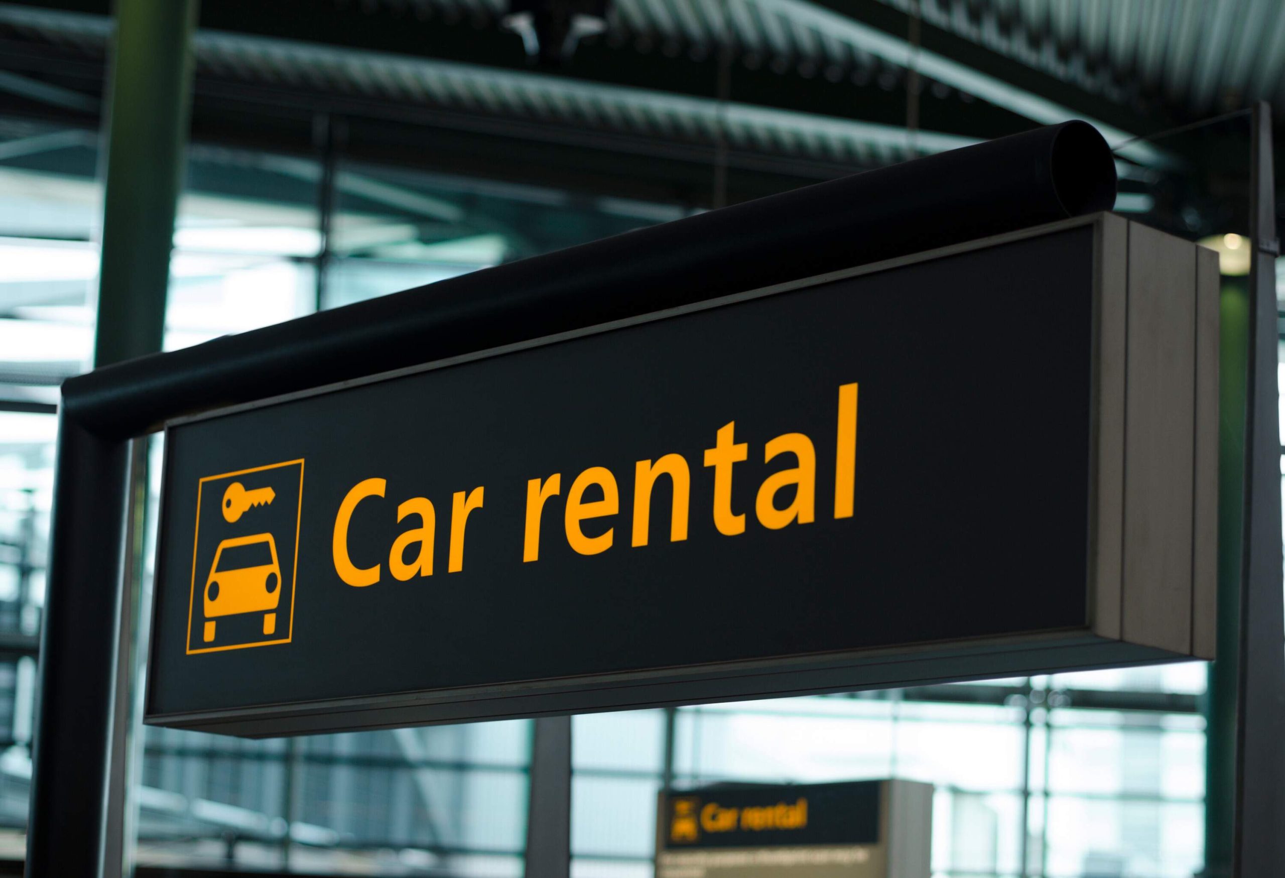 A black car rental signage hung at the airport.