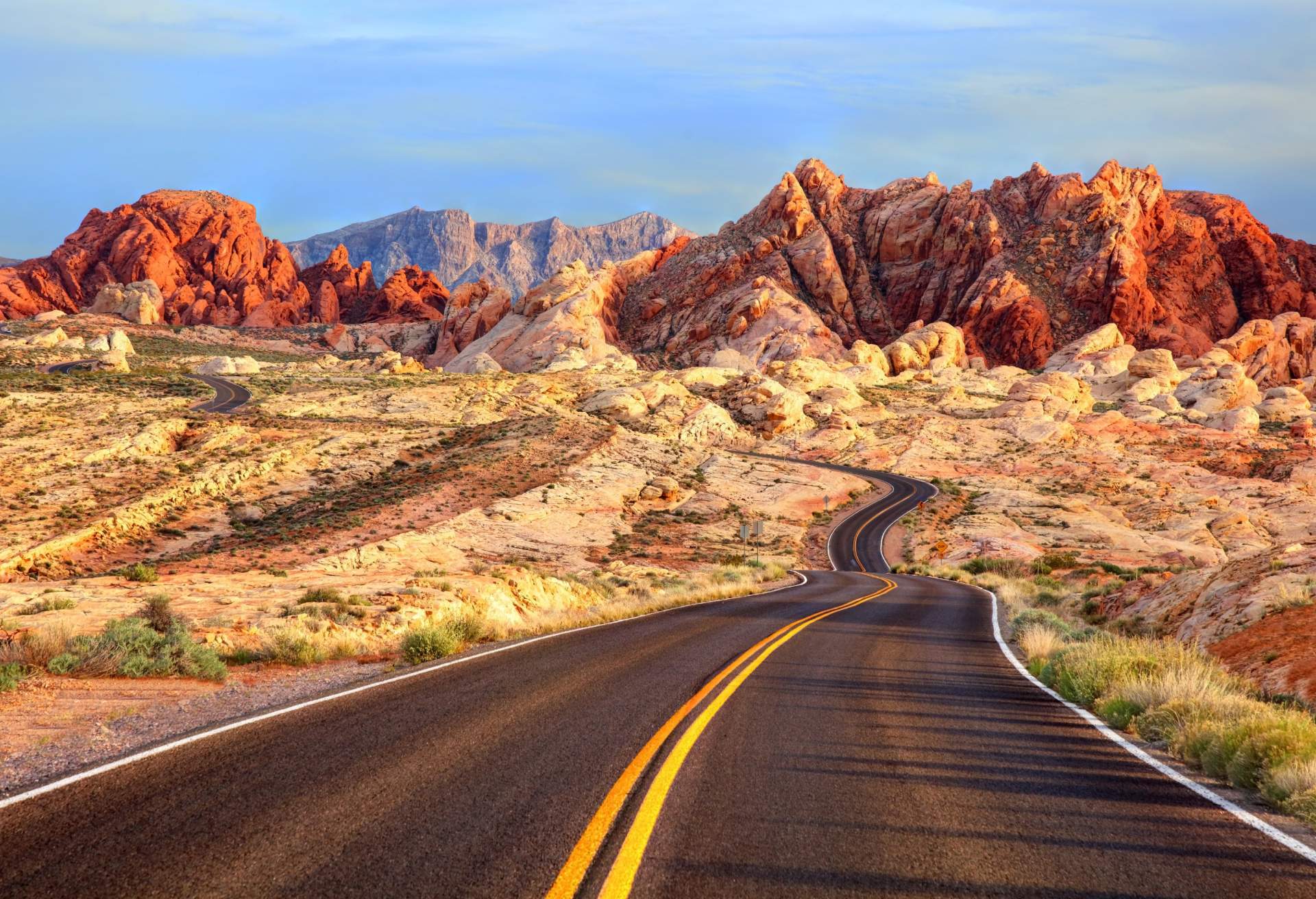 Winding roads weave through red sandstone under a clear blue sky in Valley of Fire, Nevada 