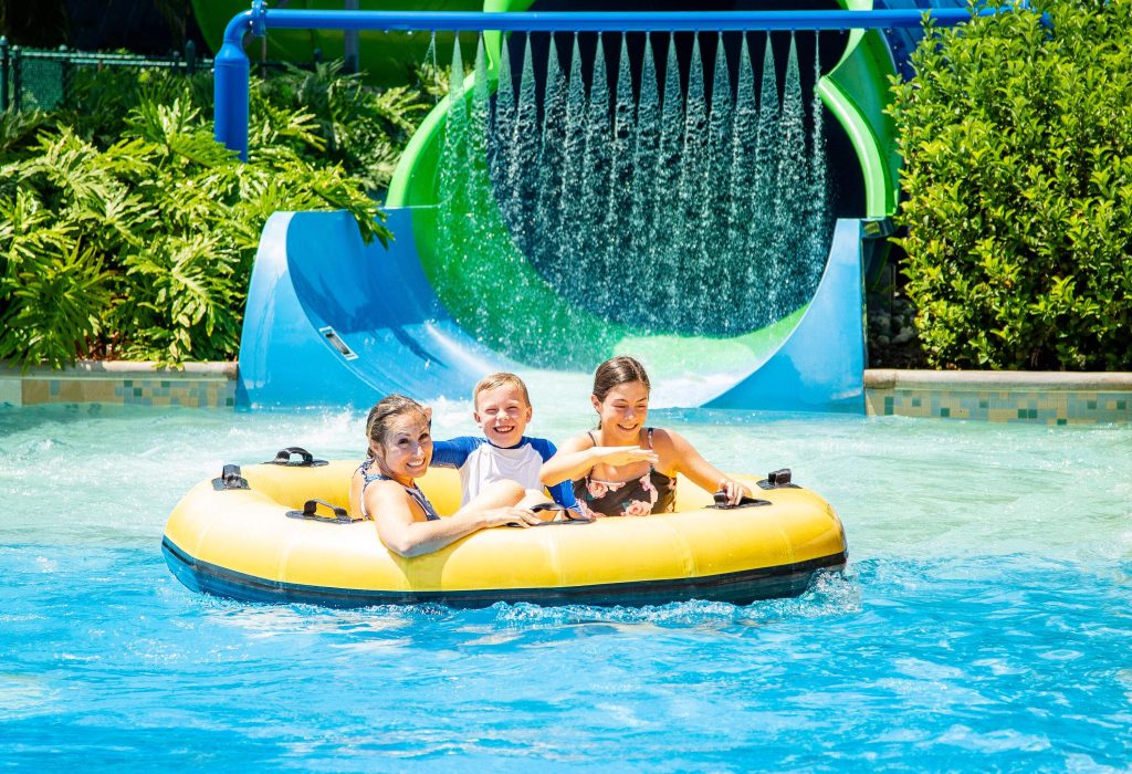 Happy family of three in the pool on a round inflatable boat.