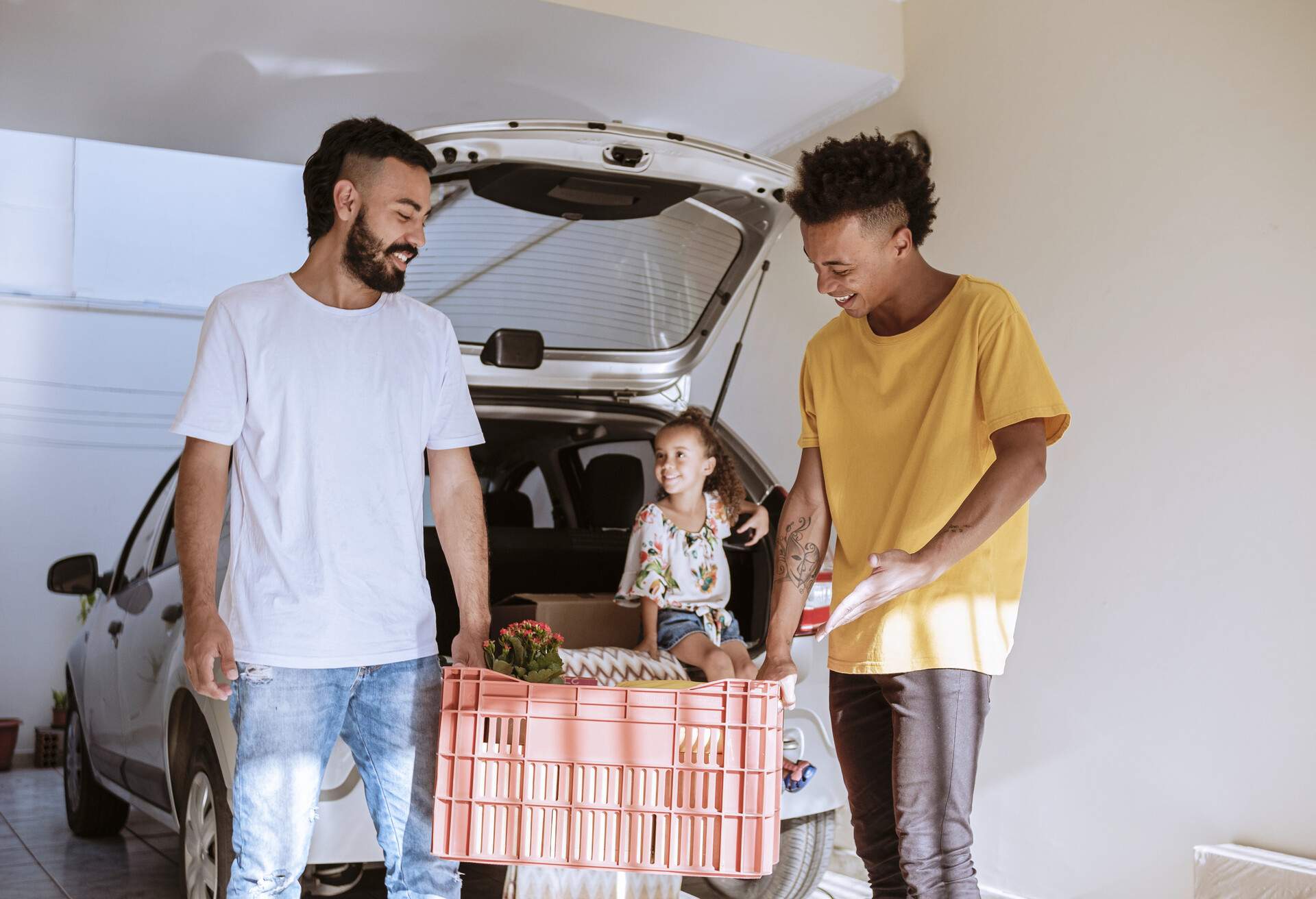 A family in their garage, unloading the trunk of the car