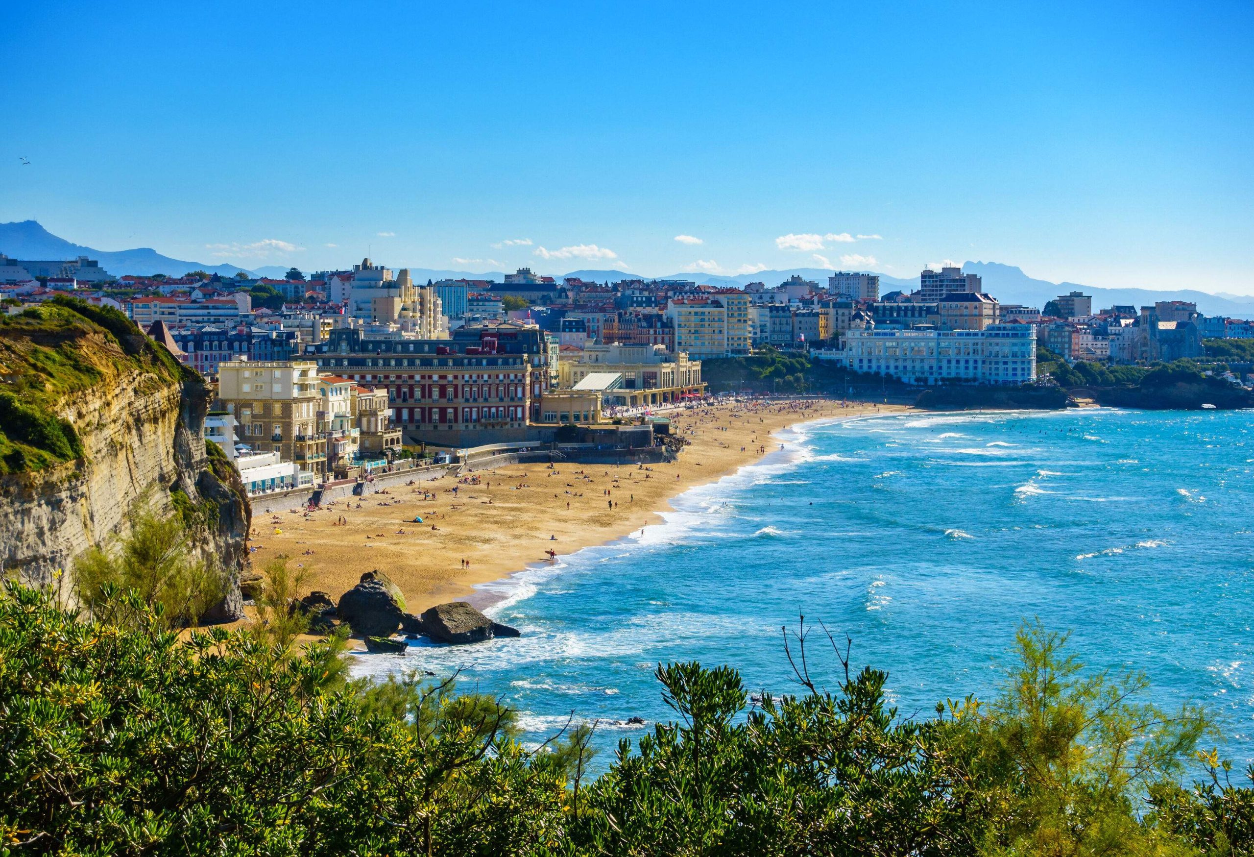 A coastal community with multi-storey buildings and plenty of beachgoers.