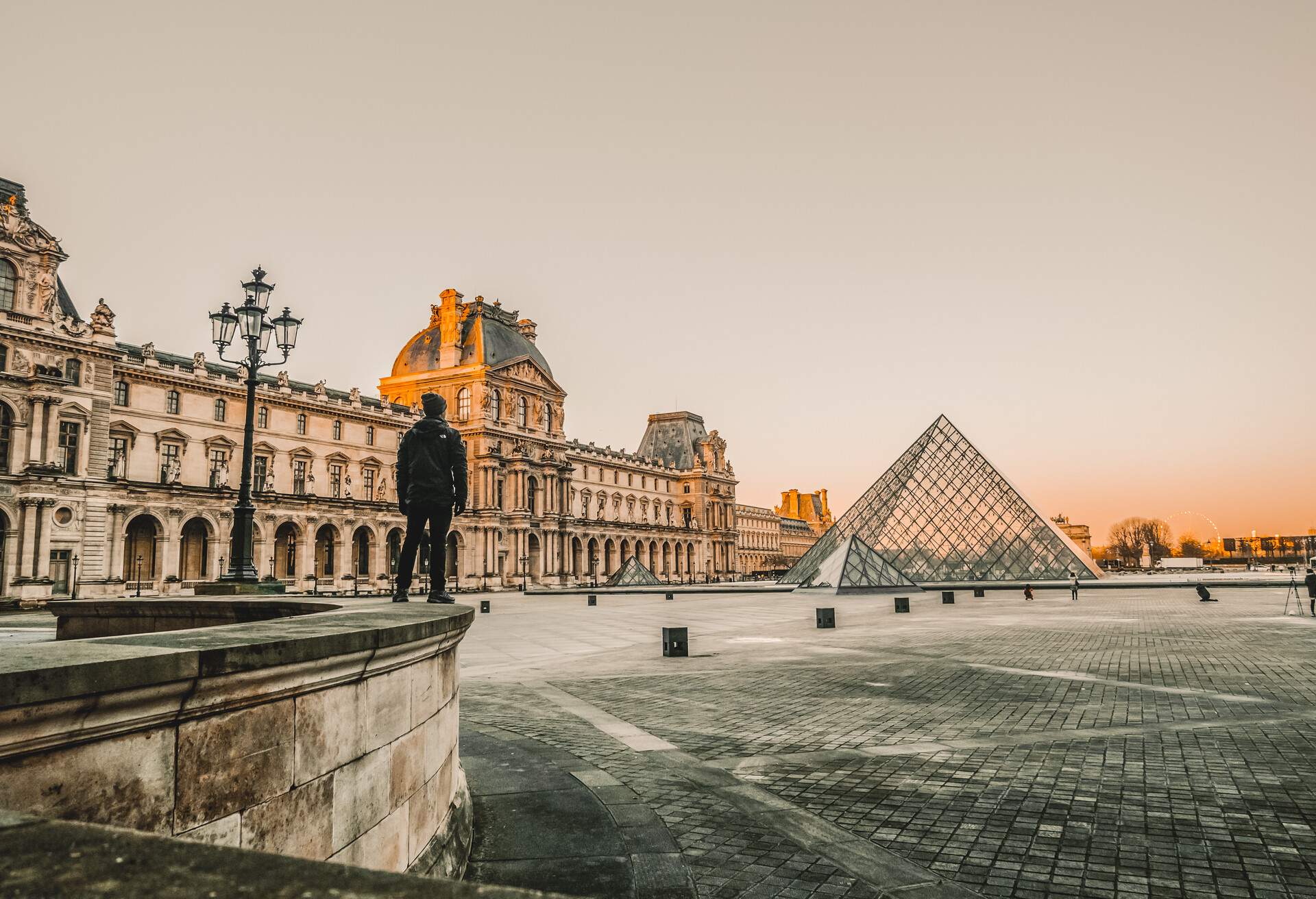 Man overlooking the glass pyramids of the Louvre Museum, Paris France
