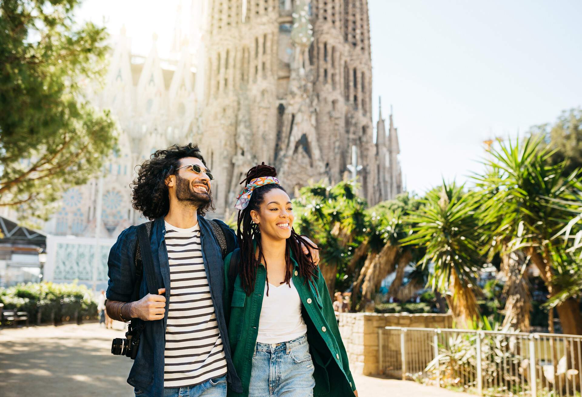 Couple walking down the street with the Sagrada Familia behind them, Barcelona Spain