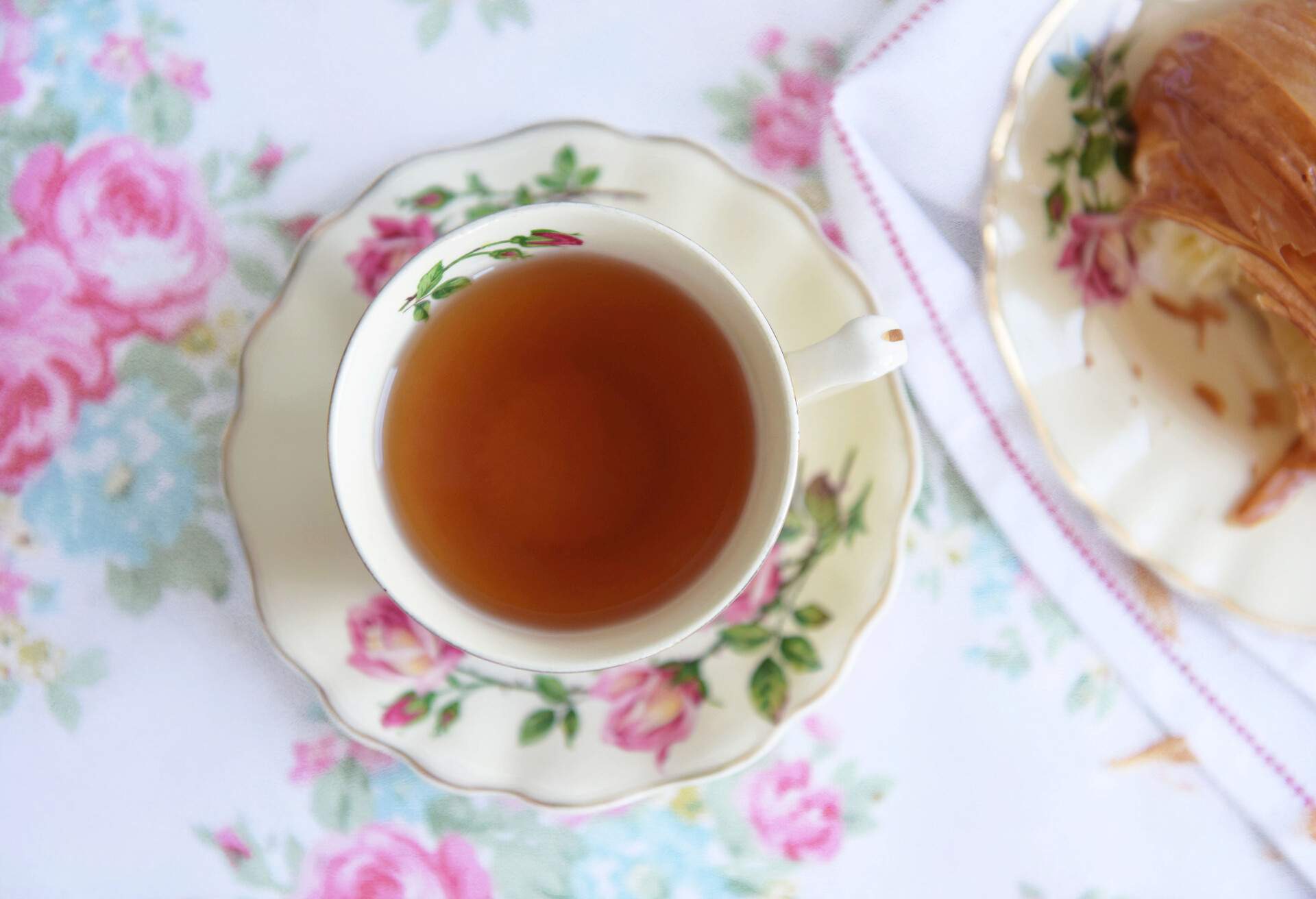 A refreshing cup of tea served on a pink rose cup and saucer set.