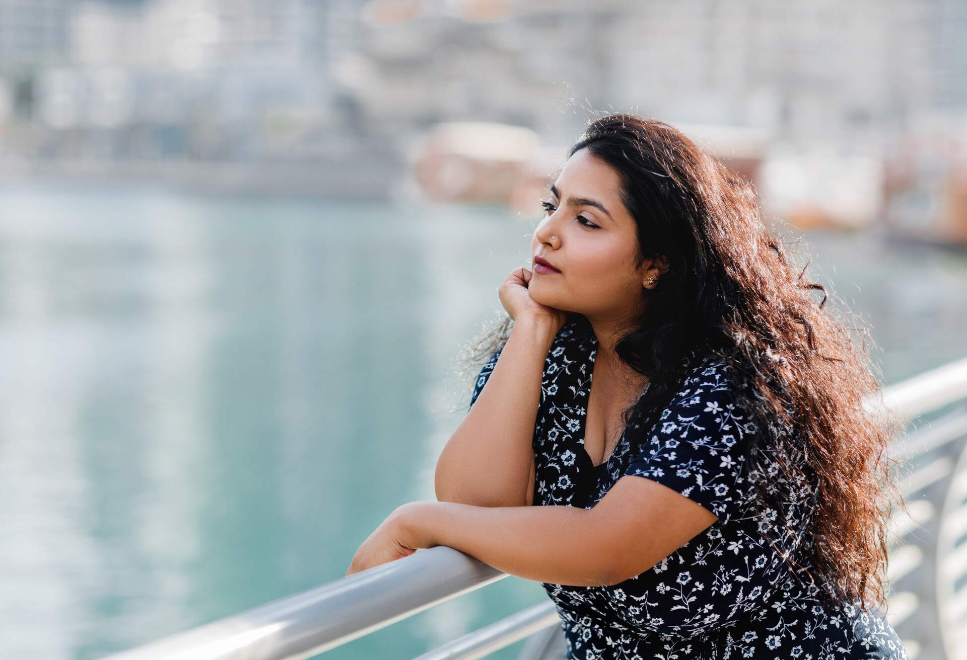 A curly long-haired woman is in deep thinking.