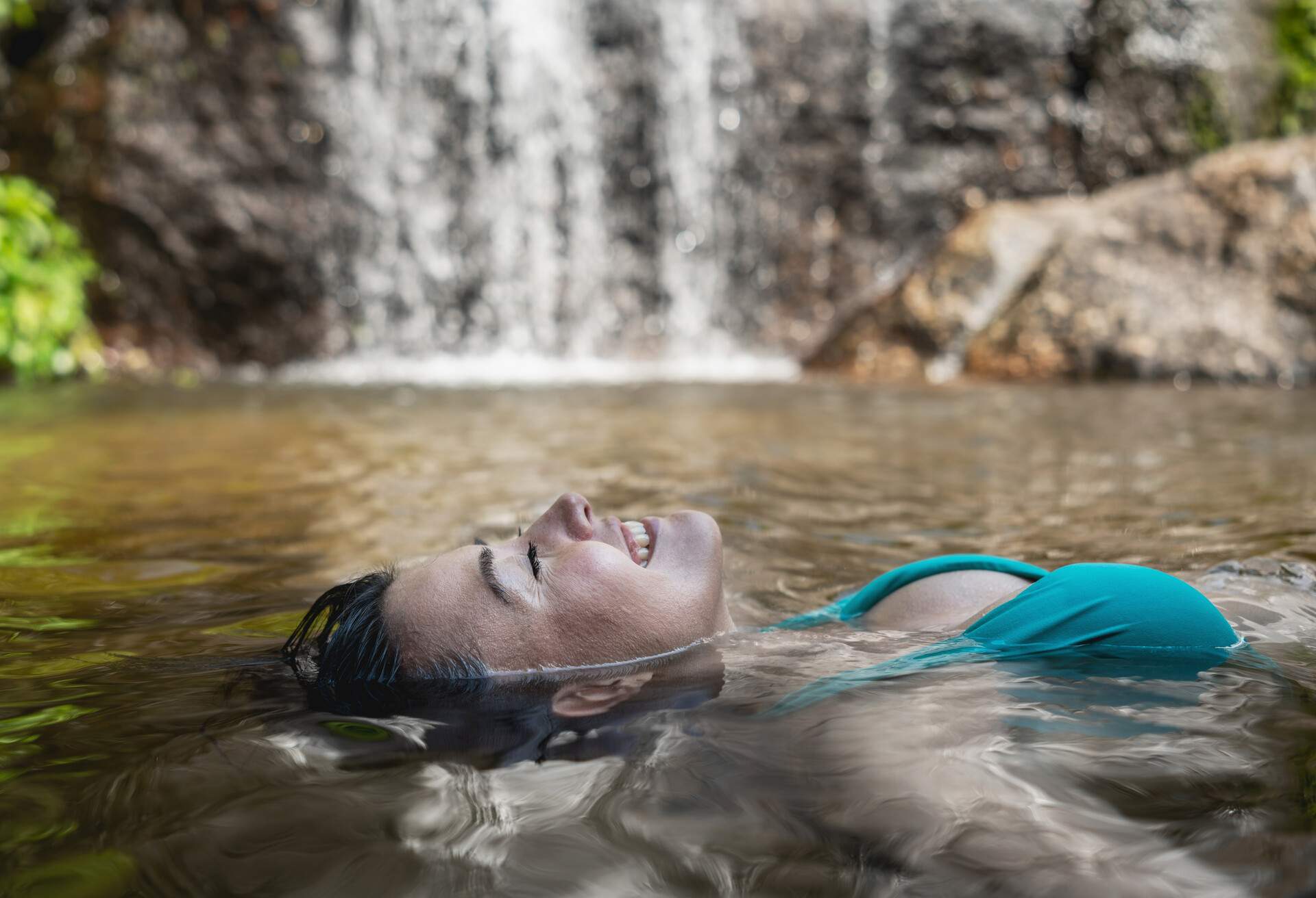 A contented woman relaxes and floats weightlessly in the water, lost in the tranquilly of the moment.