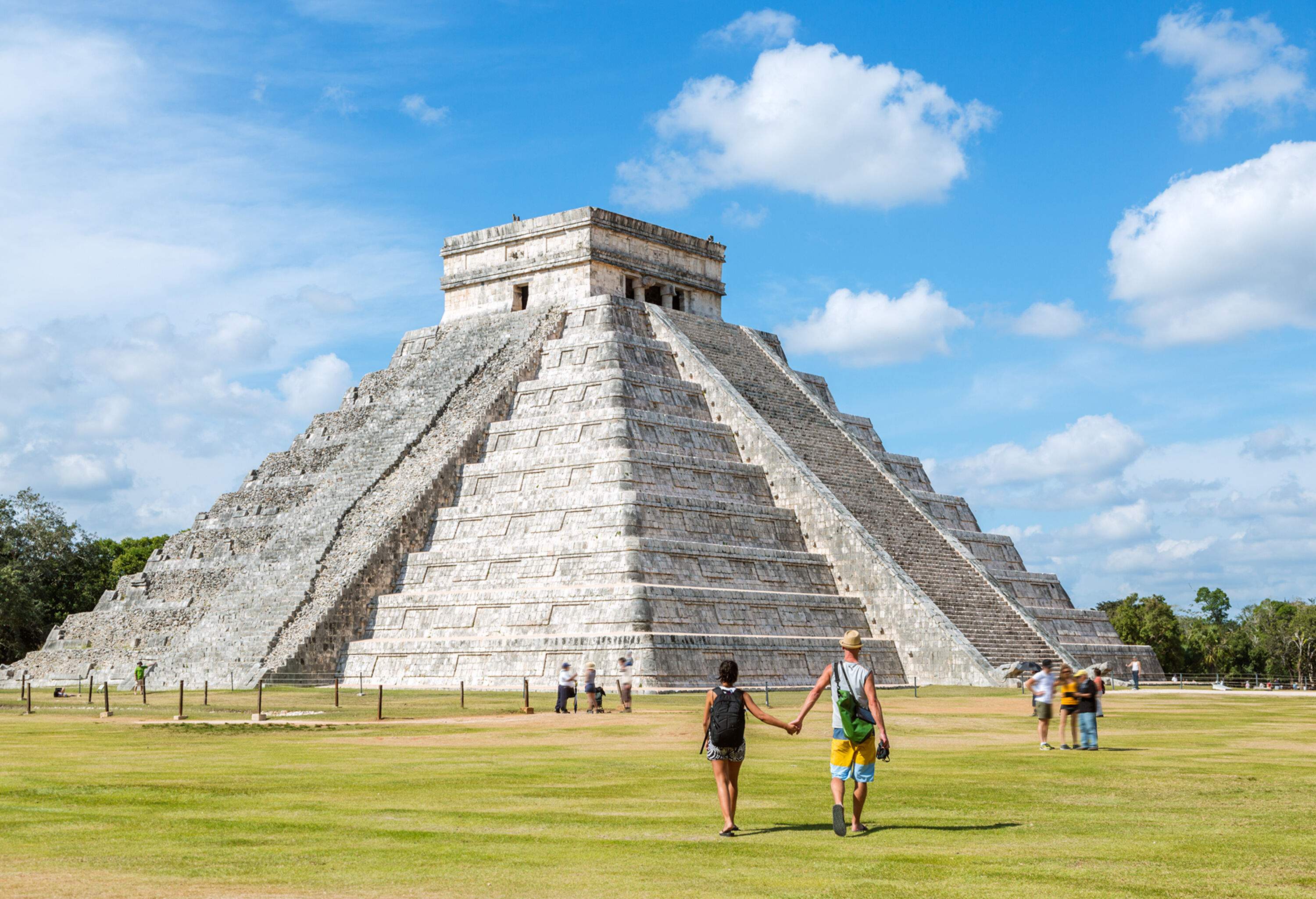 Tourist couple in front of El Castillo temple, Chichen Itza, Yucatan, Mexico (MR)