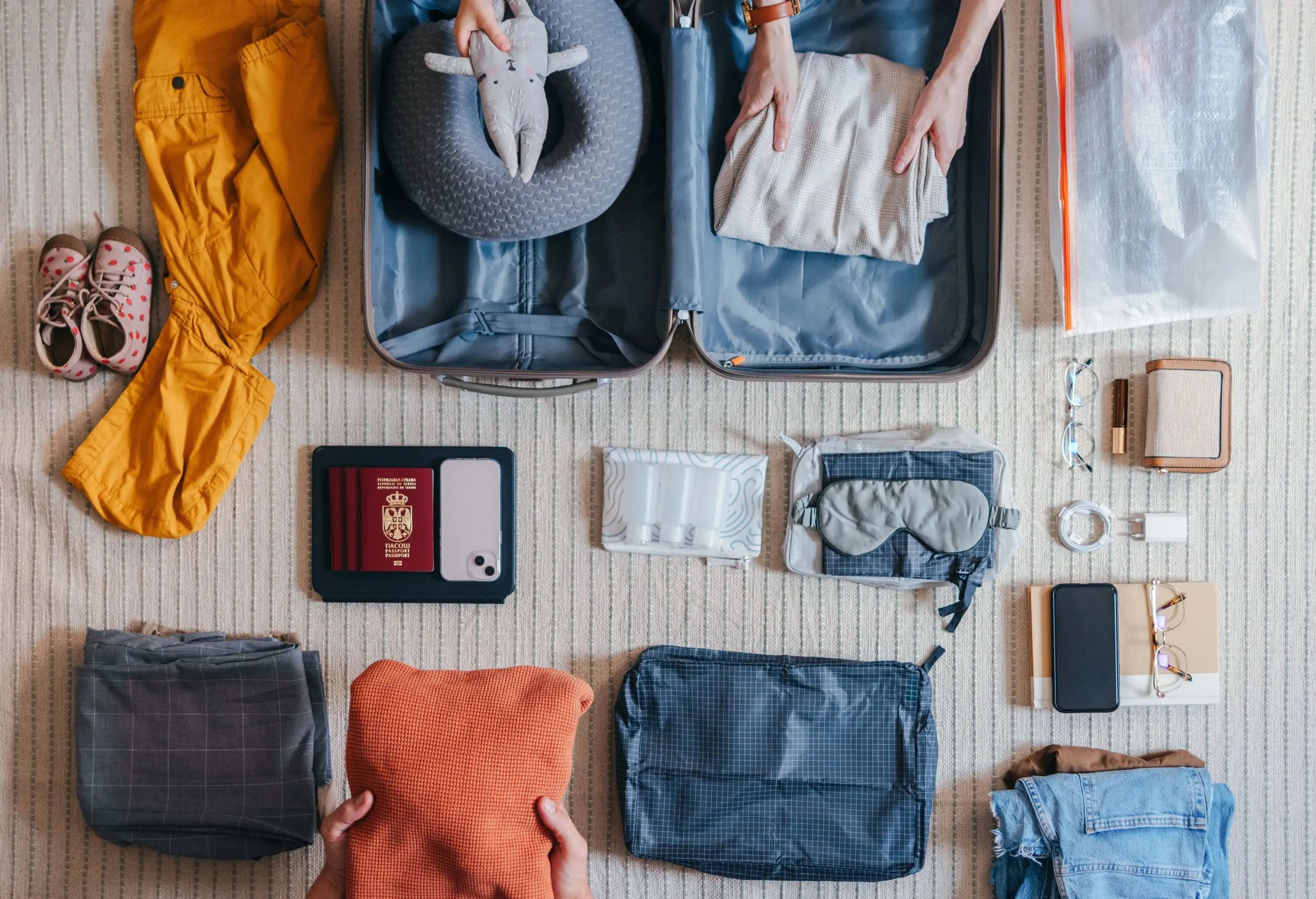 Items to pack into a carry-on passport, roller bag, pillow, laptop case