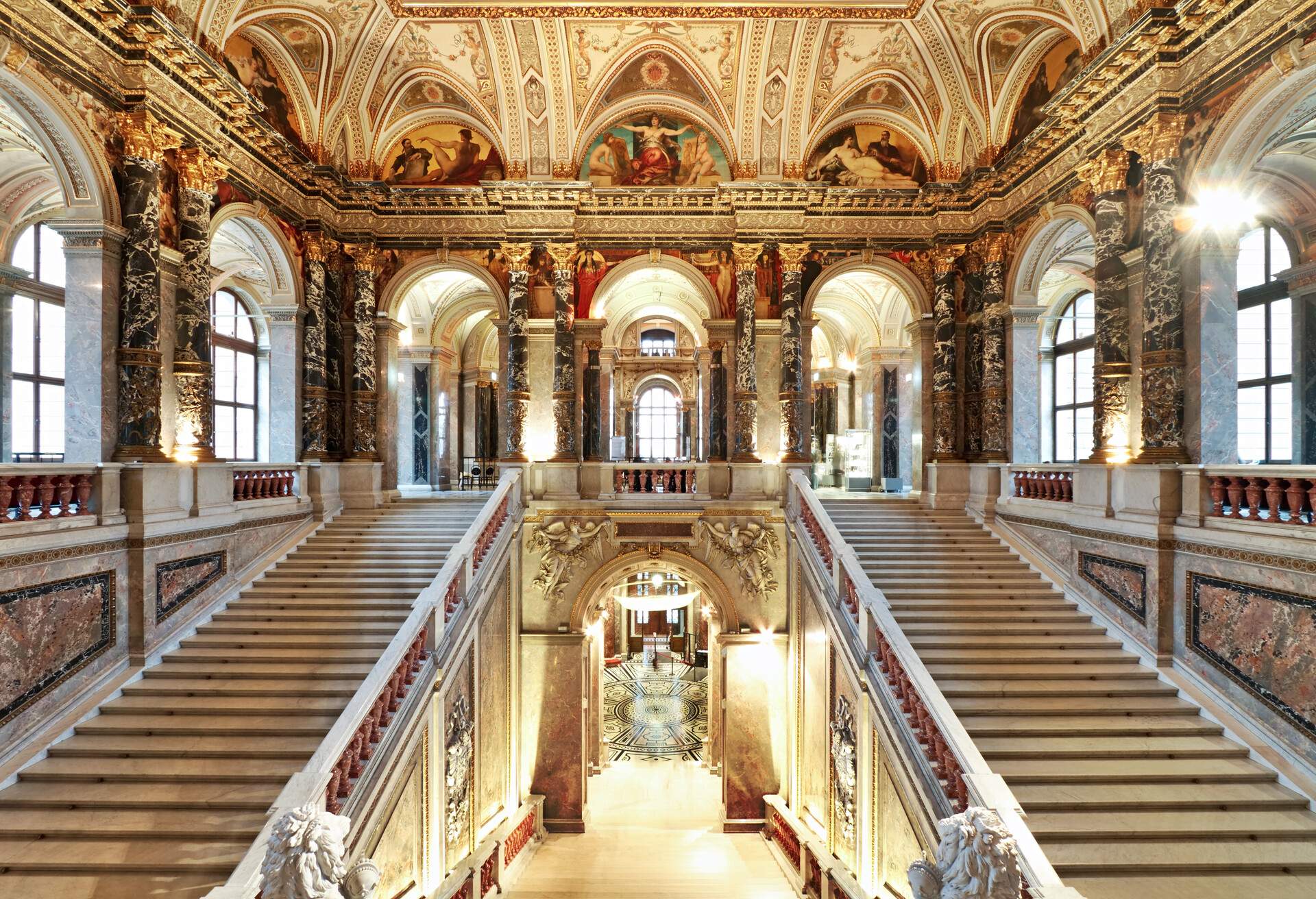 Adjacent to the grand staircase, the Kunsthistorisches Museum's interior boasts opulent marble flooring, ornate decorative mouldings, and soaring ceilings adorned with enchanting frescoes.