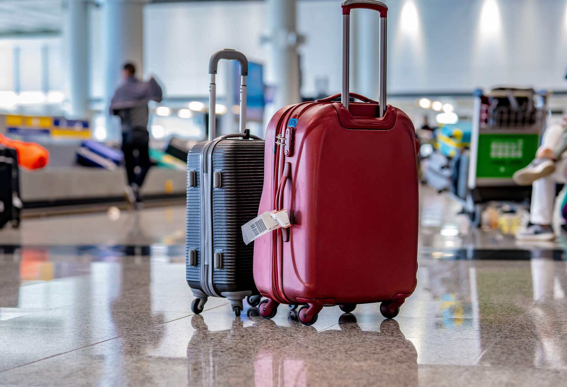 Luggage for travellers is neatly arranged on the pristine airport terminal floor.