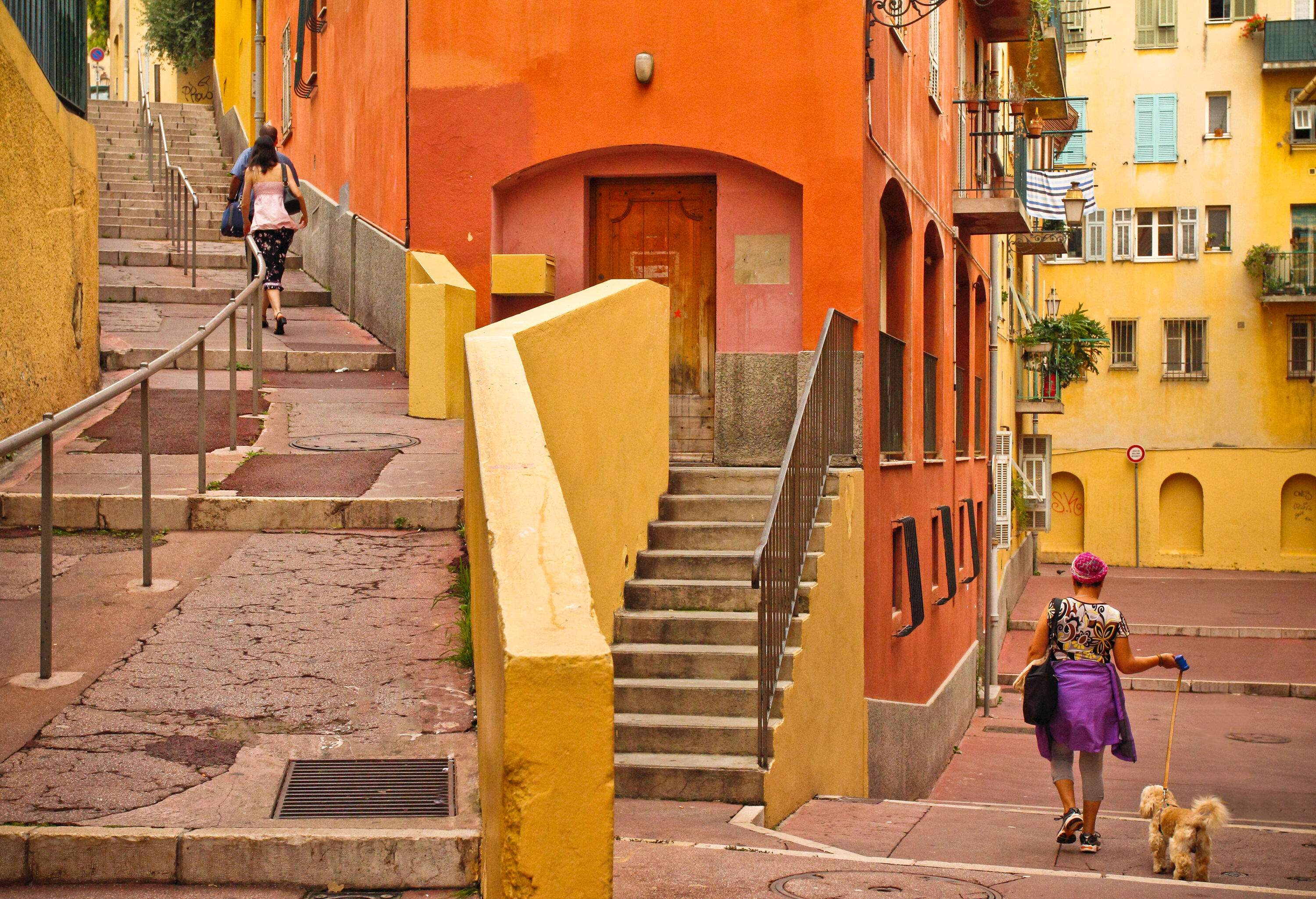 A vibrant street adorned with stairs flanked by a charming array of colourful and aged buildings.