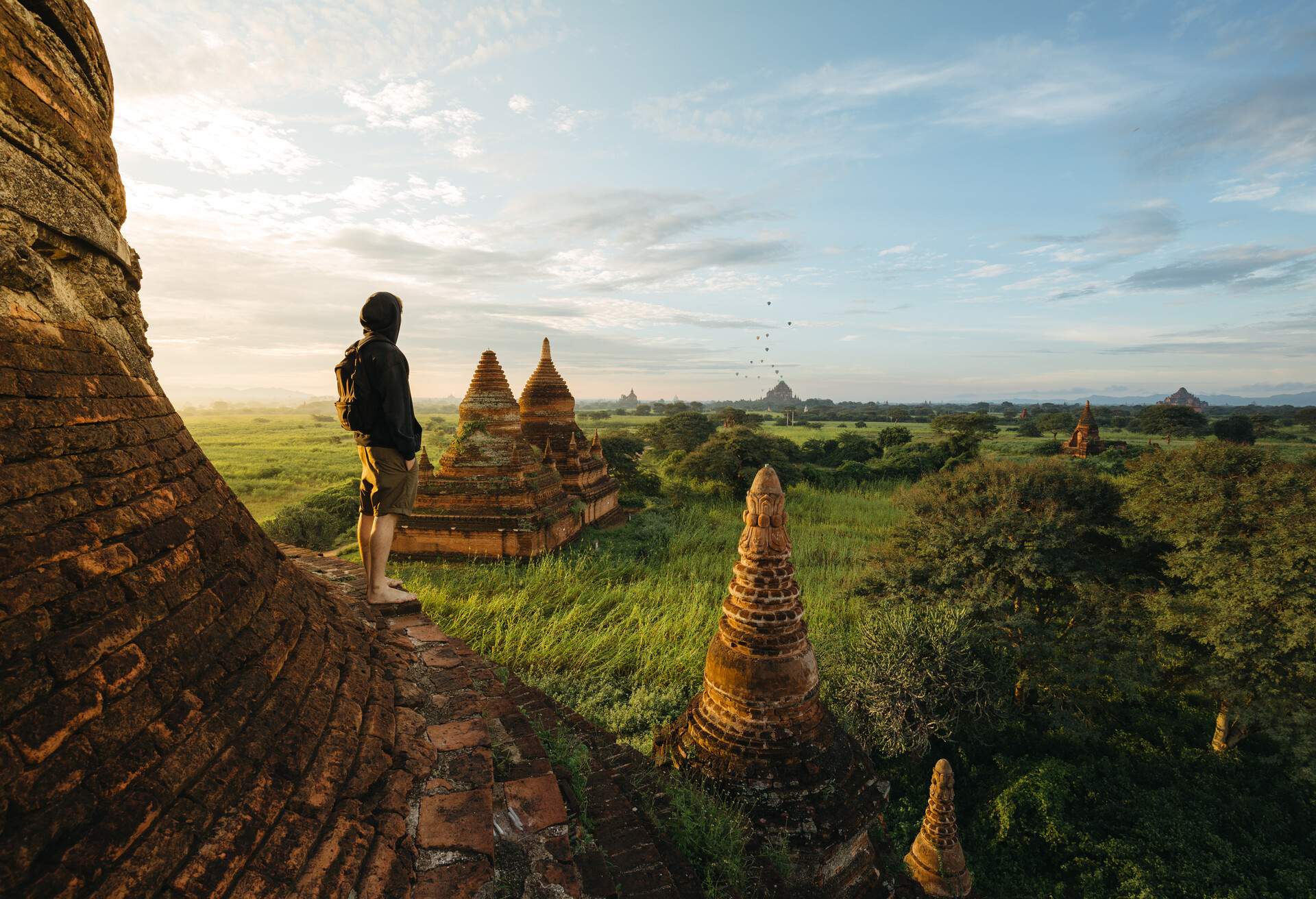 Male traveler standing on pagoda at sunrise in Bagan, Myanmar