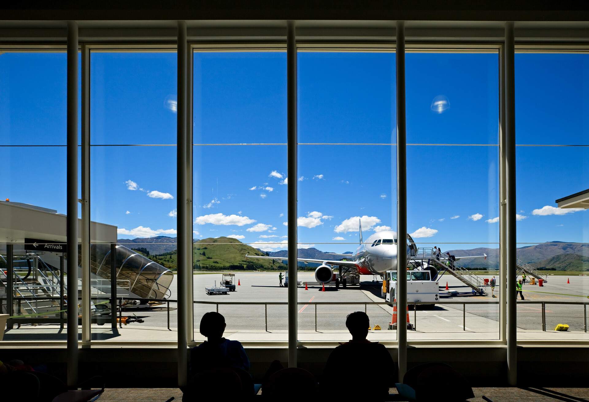 View of airport through window and silouhette of people