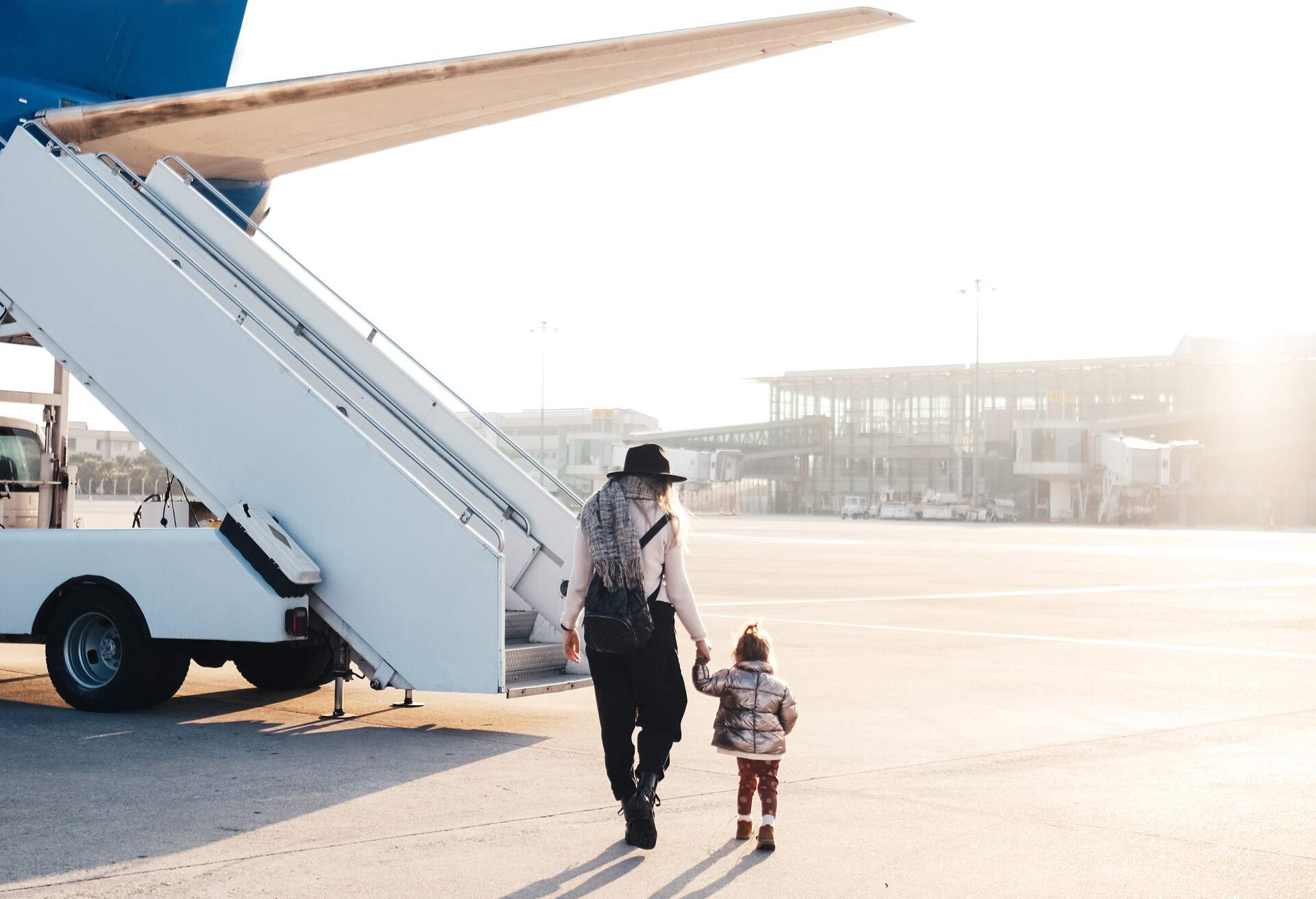 Happy family moving up the staircase towards the plane.