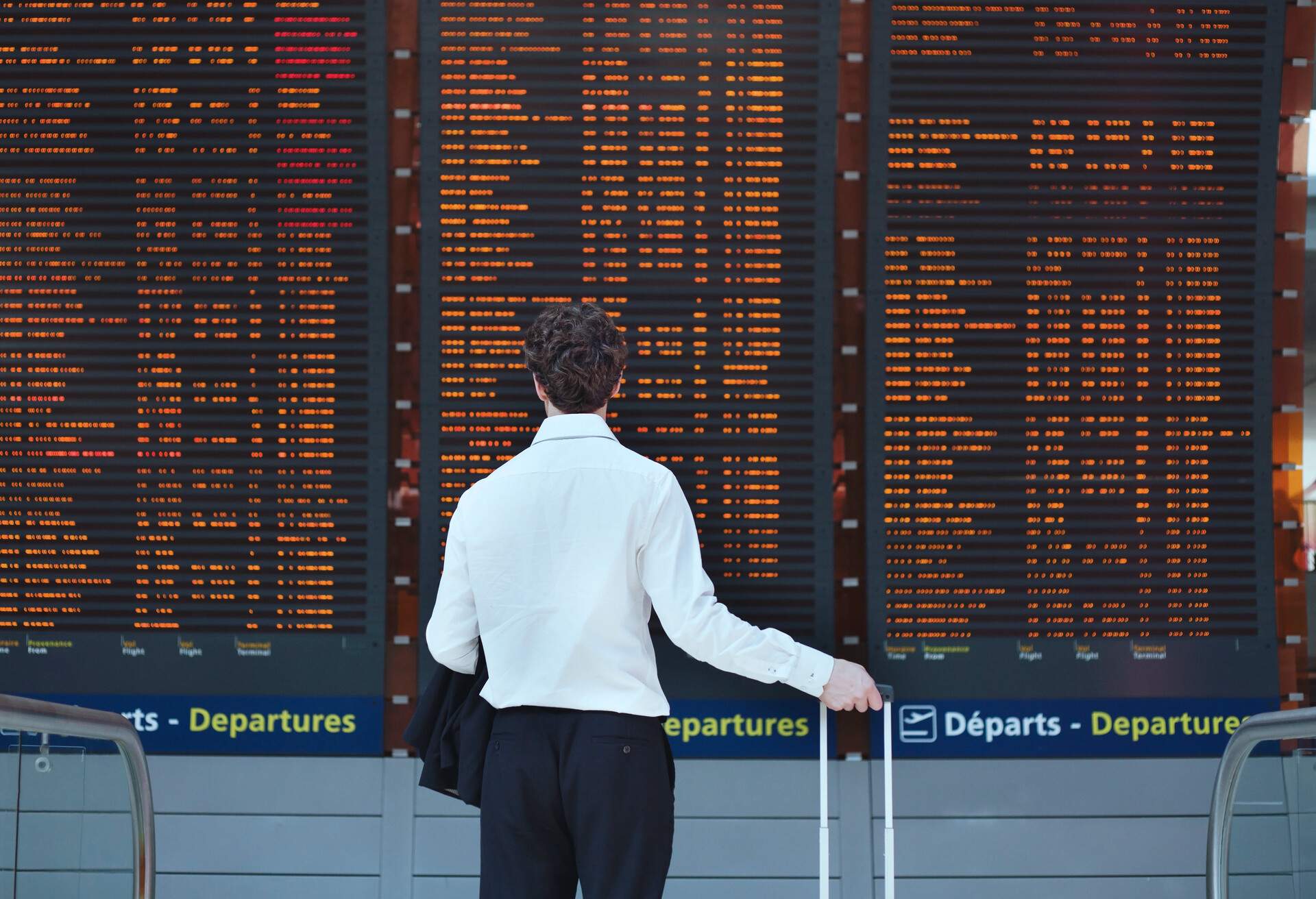 Passenger looking at timetable board at the airport.
