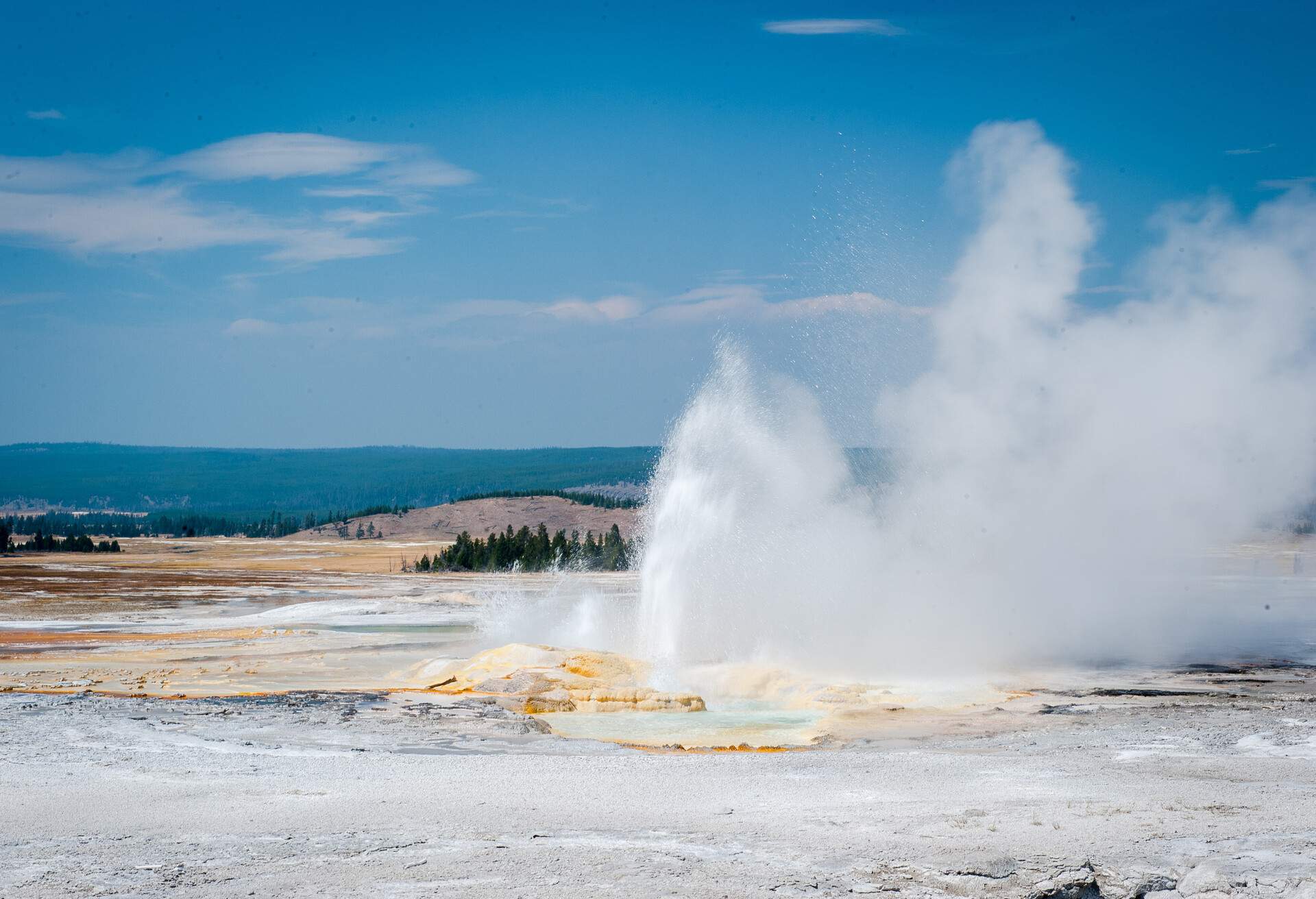 Water discharge constantly pours out on a geyser's crater.