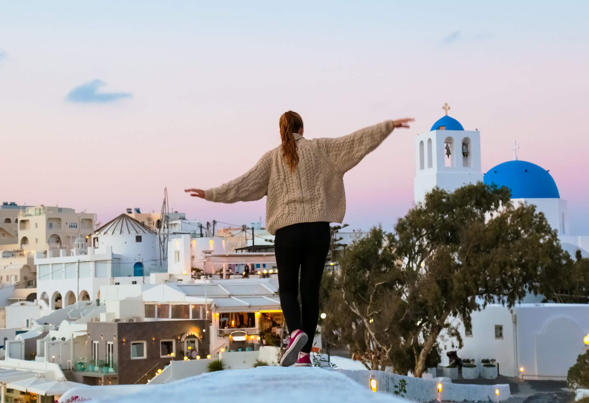 Girl walking through the streets of Santorini, Greece.