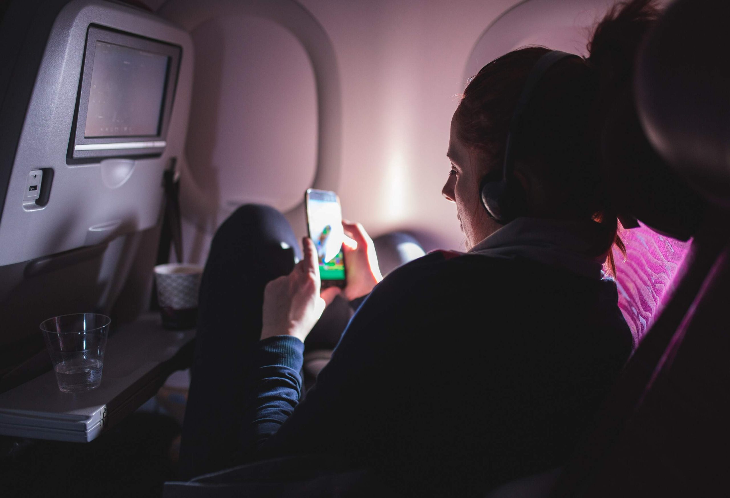 Woman Using Cell Phone And Sitting Comfortably in Airplane.